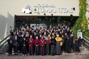 Absolwenci oraz władze uczelni stoją tłumnie na schodach przed budynkiem Akademii Humanitas w Sosnowcu