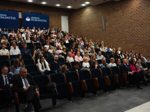 Publiczność w sali audytoryjnej Akademii Humanitas podczas konferencji, na tle widoczne banery uczelni.