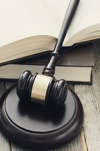 Młotek sędziowski i otwarta książka symbolizujące wymiar sprawiedliwości.