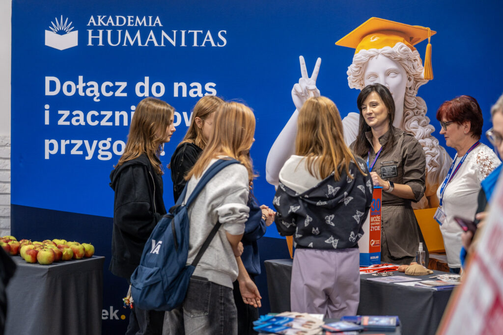 Grupa dziewcząt uczestniczy w wydarzeniu Girls Week. Rozmawiają z prelegentką, która prowadziła wykład.