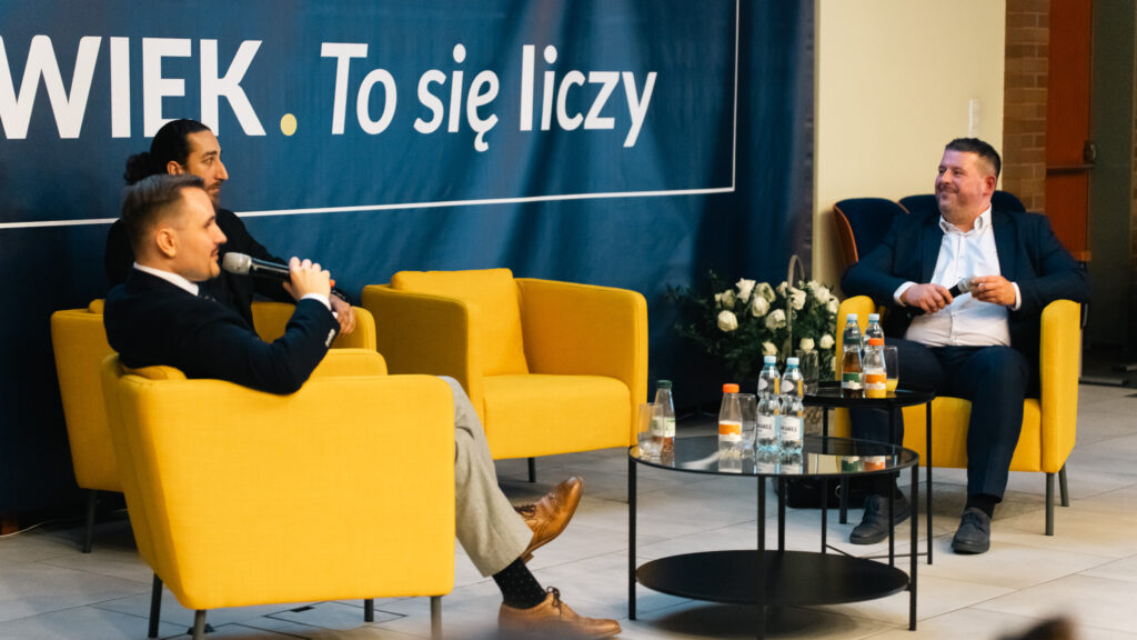 Debata w Akademii Humanitas – prelegenci rozmawiają na scenie.