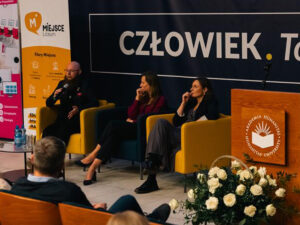 Prelegenci podczas konferencji w Akademii Humanitas na tle napisu „Człowiek. To się liczy.”