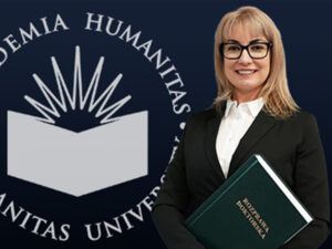 Kobieta w eleganckim stroju, trzymająca zielony tom z napisem ‘Rozprawa doktorska’, stoi na tle logotypu Akademii Humanitas.