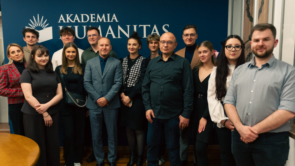 Grupowe zdjęcie Samorządu Studenckiego Akademii Humanitas stojącego przed ścianką z logo uczelni. Uczestnicy pozują do wspólnej fotografii w eleganckim, oficjalnym otoczeniu stojącego przed ścianką z logo uczelni. Uczestnicy pozują do wspólnej fotografii w eleganckim, oficjalnym otoczeniu.