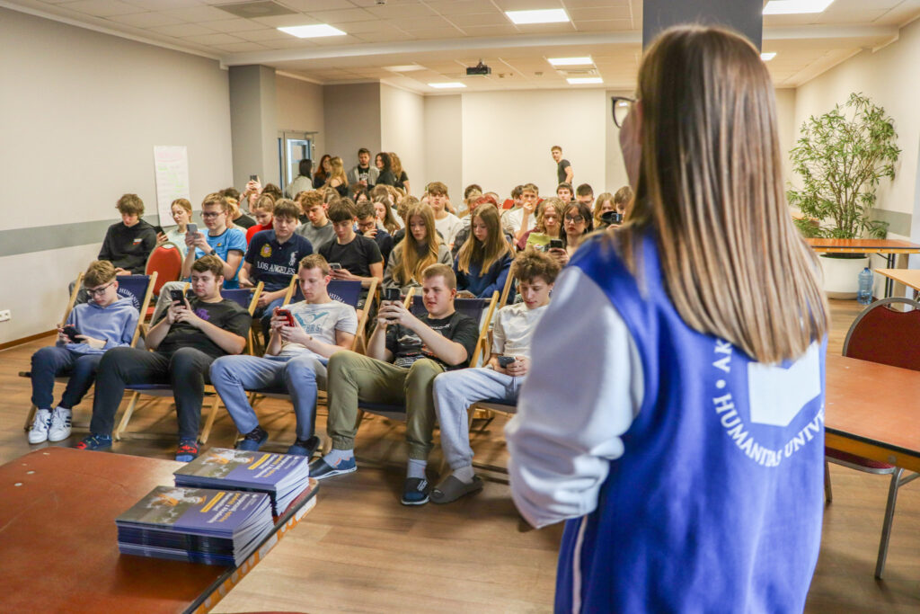 Uczniowie biorą udział w interaktywnej aktywności z użyciem telefonów podczas prezentacji. 