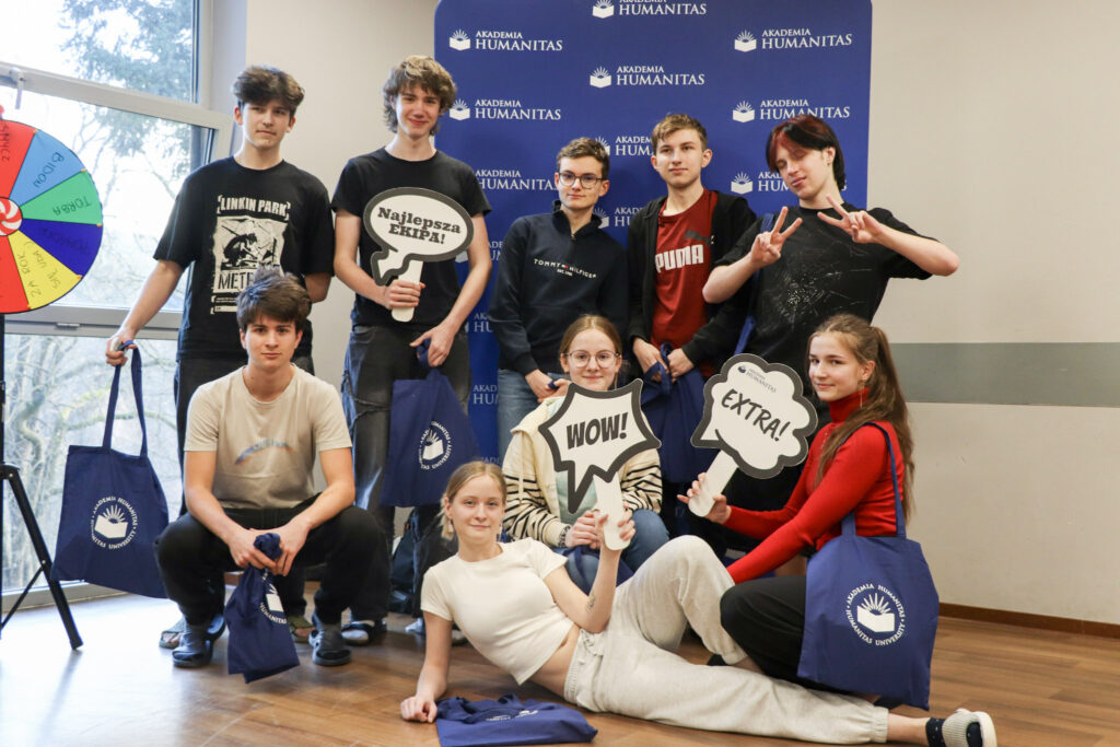 Wspólne zdjęcie uczniów z gadżetami uczelni po zakończeniu zajęć.