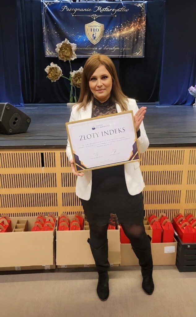 Przedstawicielka AH stoi na tle ceny ze „Złotym Indeksem” Akademii Humanitas.