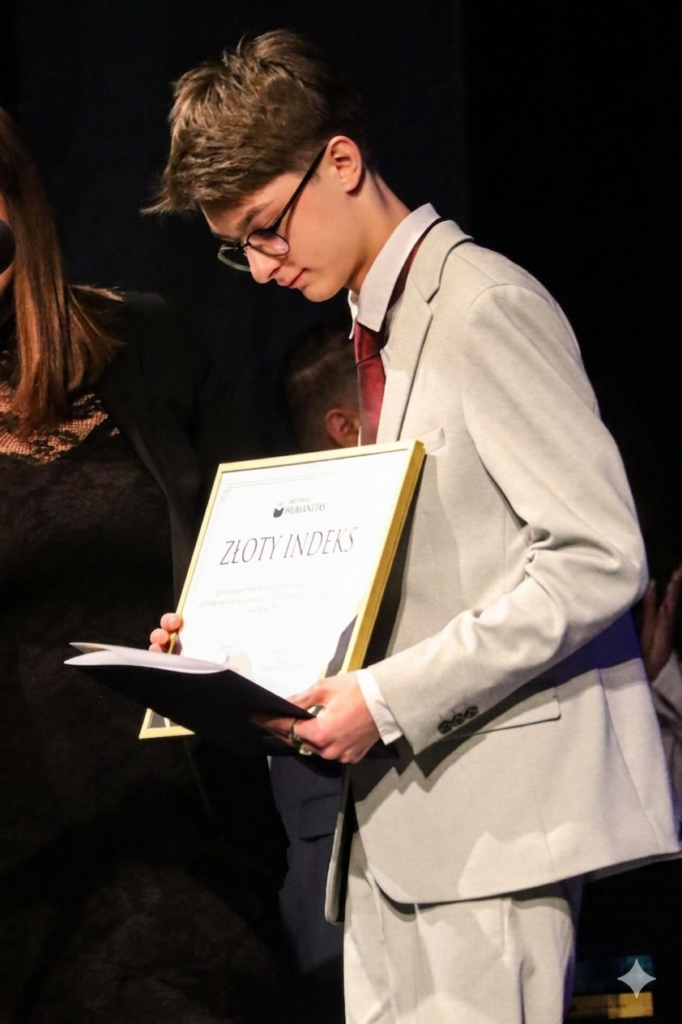 Laureat stoi na scenie ze „Złotym Indeksem” Akademii Humanitas.