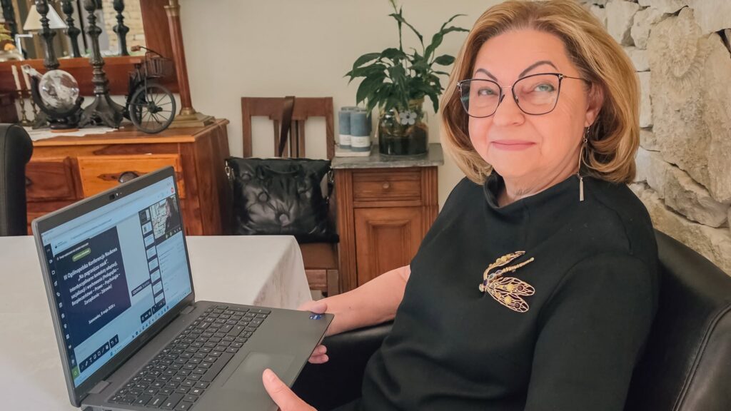 dr hab. Bożena Marzec, prof. AH – Przewodniczącej Komitetu Naukowego, siedzi przy biurku z otwartym laptopem.
