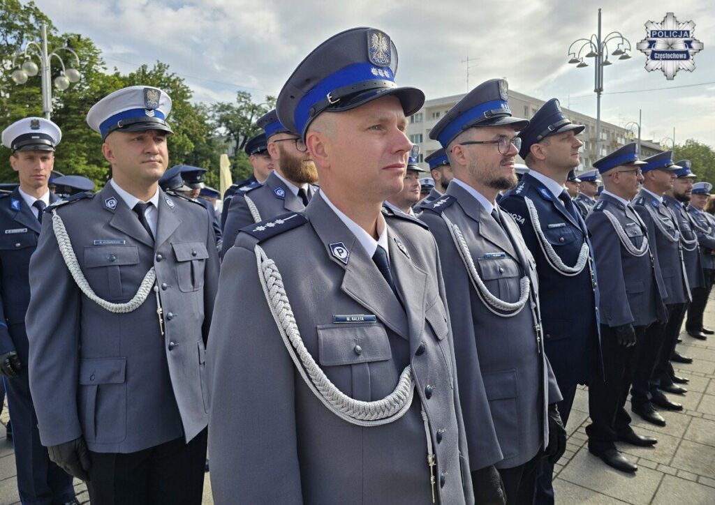 Grupa umundurowanych funkcjonariuszy stojąca w szyku podczas uroczystości plenerowej.