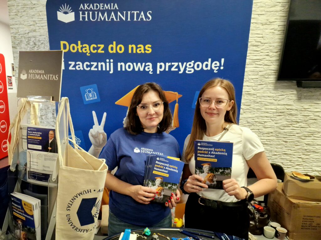 Dwie przedstawicielki Akademii Humanitas prezentują materiały informacyjne dotyczące kierunków studiów na stoisku promocyjnym podczas Dnia Kariery.