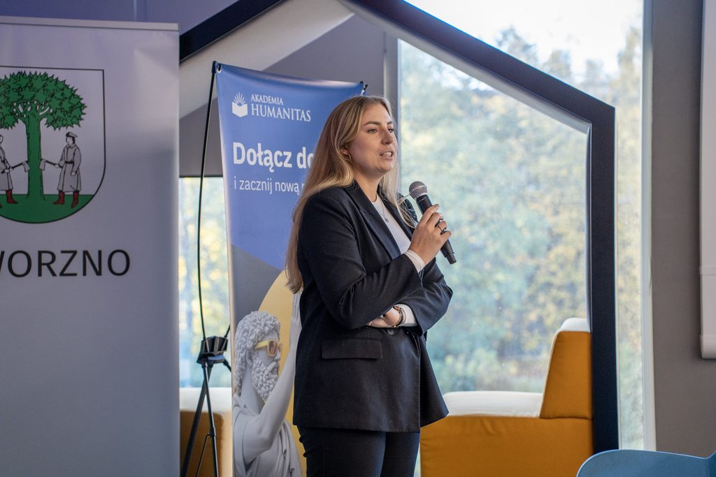 Przedstawicielka Akademii Humanitas przemawia podczas X Jaworznickich Dni dla Biznesu na tle baneru uczelni.