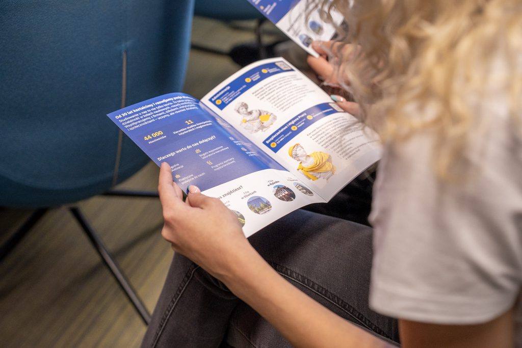 Uczestniczka X Jaworznickich Dni dla Biznesu przegląda broszurę informacyjną Akademii Humanitas dotyczącą oferty edukacyjnej uczelni.