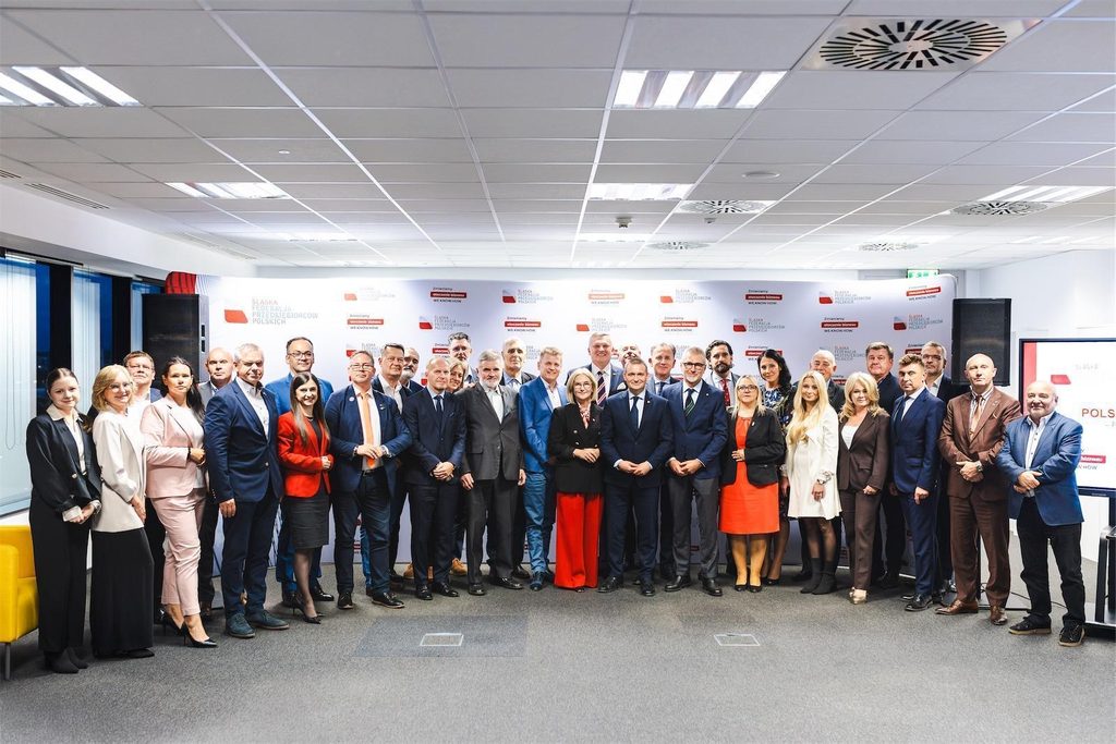 Uczestnicy spotkania pozują do wspólnego zdjęcia na tle ścianki Śląskiej Federacji Przedsiębiorców Polskich.