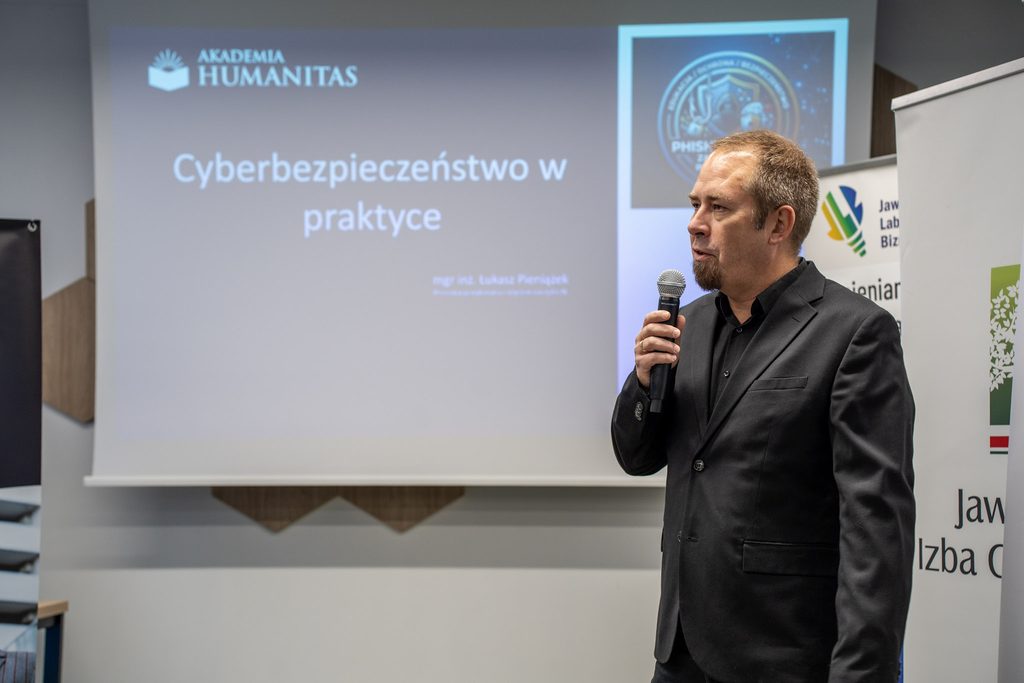 Ekspert z mikrofonem prowadzi prezentację „Cyberbezpieczeństwo w praktyce” przygotowaną przez Akademię Humanitas.