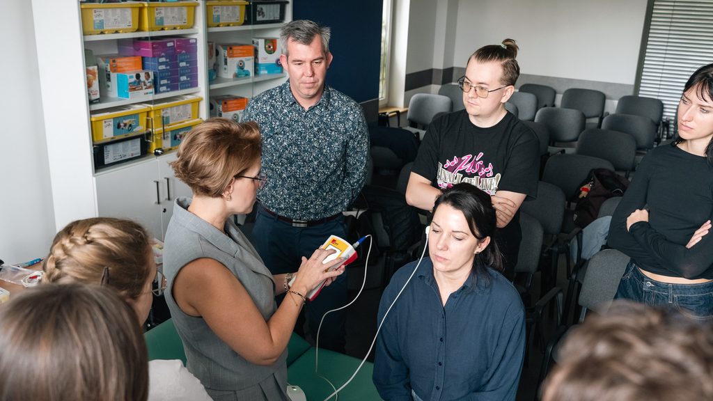 Uczestnicy warsztatów obserwują prezentację działania urządzenia diagnostycznego wykorzystywanego w pracy elektroradiologa.