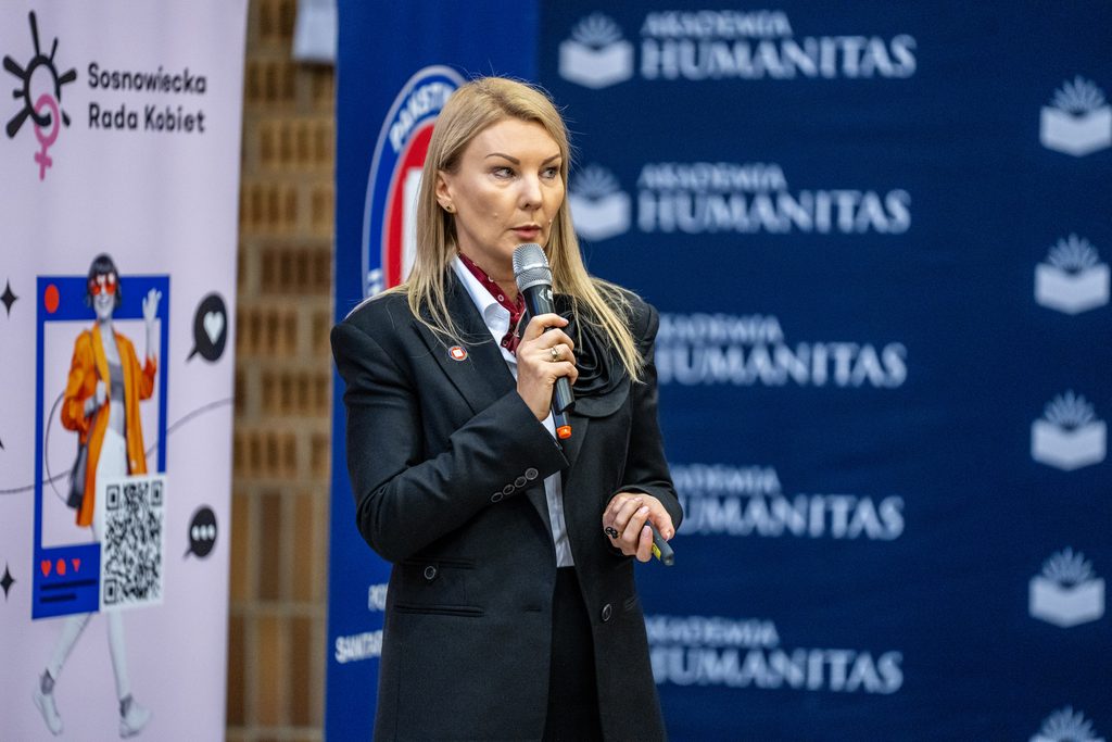 Przedstawicielka Sosnowieckiej Rady Kobiet przemawia z mikrofonem podczas wydarzenia Girls’ Week w Akademii Humanitas.