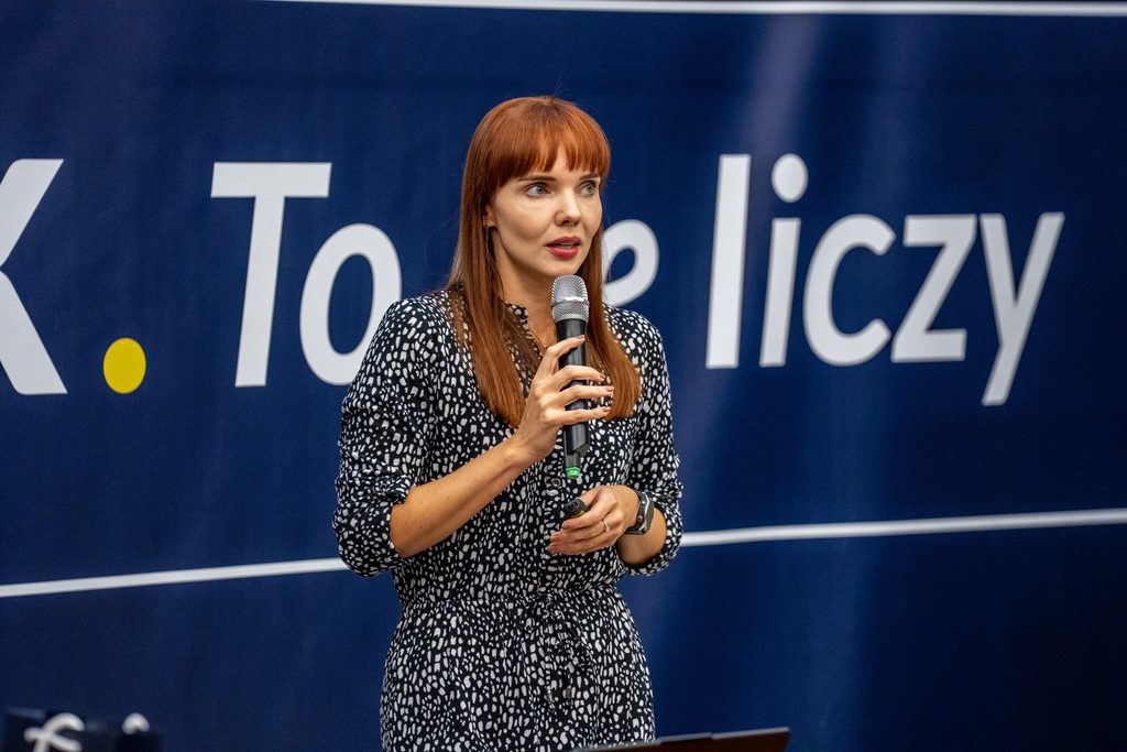 Prelegentka z mikrofonem prowadzi wystąpienie podczas wydarzenia Girls’ Week.