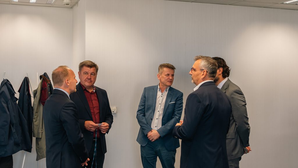 Uczestnicy spotkania biznesowego rozmawiają w kuluarach.