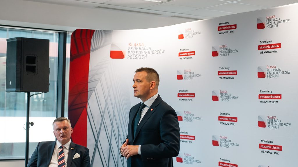 Prelegent występuje przed uczestnikami spotkania biznesowego.