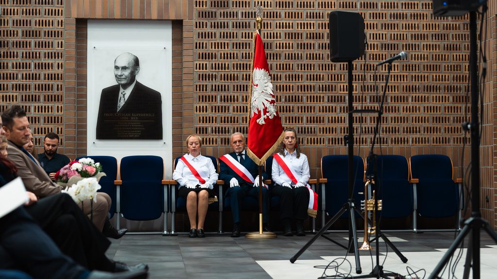 Poczet sztandarowy z flagą Polski podczas inauguracji UTW. W tle portret profesora Czesława Kupisiewicza.