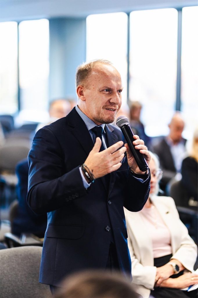 Rektor Akademii Humanitas, dr MAriusz Lekston, zabiera głos podczas dyskusji, trzymając mikrofon.